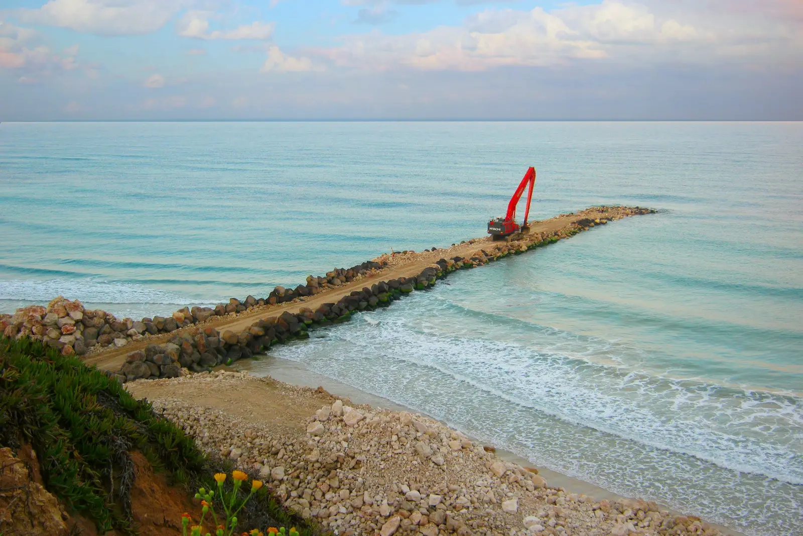 סלעים ומפרש מול חוף הים
